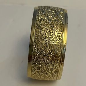 Gold colored metal cuff bracelet with heart design
